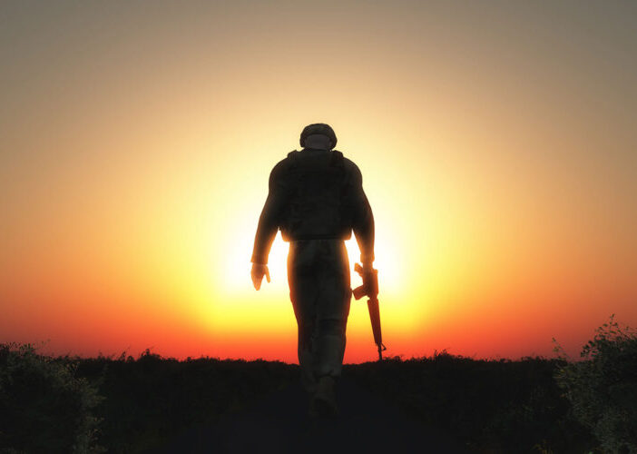 silhouette of soldier walking into sunset