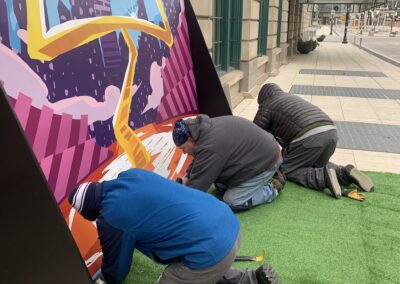 three people assembling mural frame