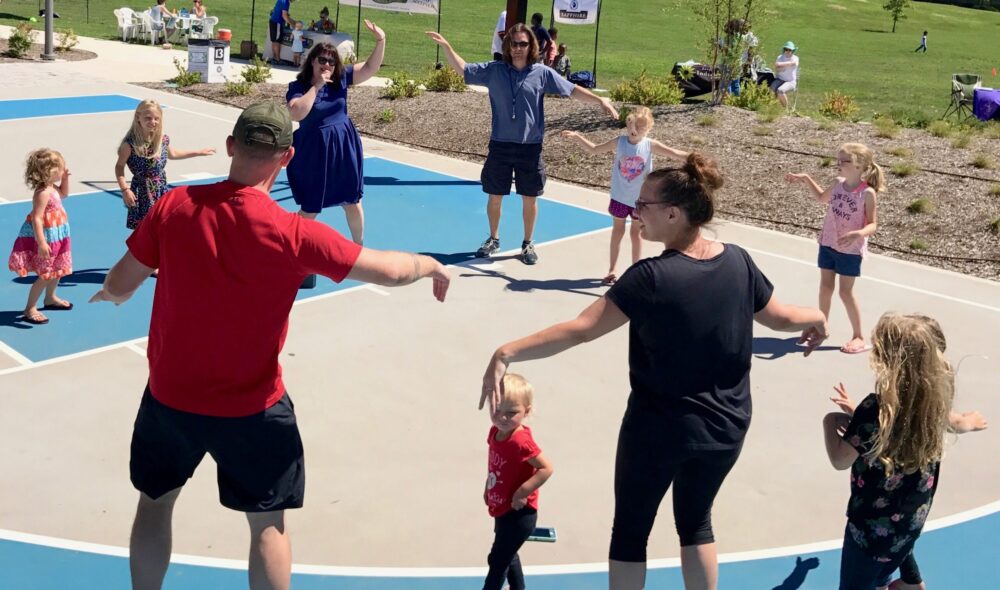 children and parents playing together in Tarkington Park