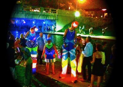 LED-lit stilt walkers with crowd