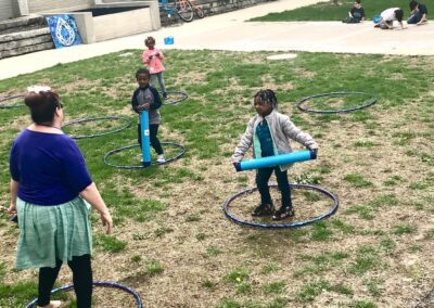 three small children laughing while hula hooping