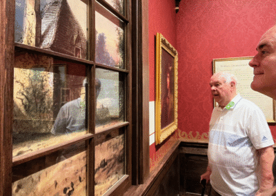 Two men observing artwork in gallery.