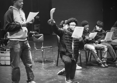 Young actors in theater rehearsal holding scripts