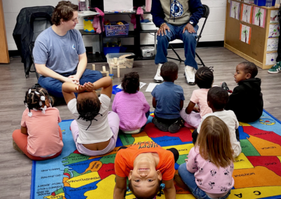 Children in preschool circle; child upside-down smiling