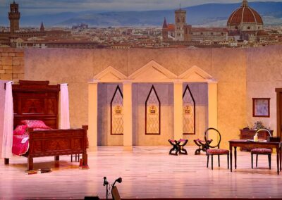 Theatrical bedroom set with city skyline backdrop