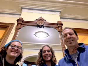 Three smiling people taking a selfie indoors