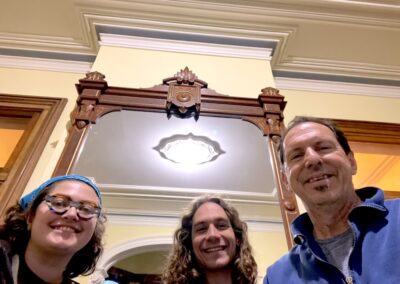 Three smiling people taking a selfie indoors