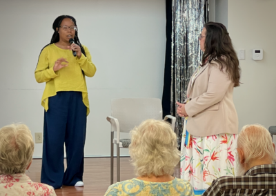 Speaker with microphone addressing senior audience