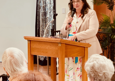 Woman speaking at wooden podium to audience