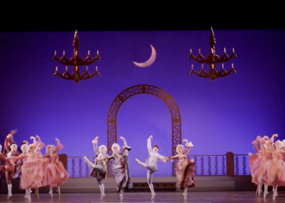 Ballet dancers under crescent moon and chandeliers